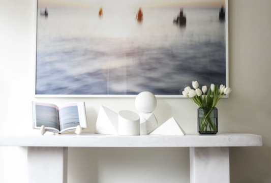 Abstract Surfers photo by César above a resin console with white geometric objects (Photograph courtesy of Daryl Nicole Scott)