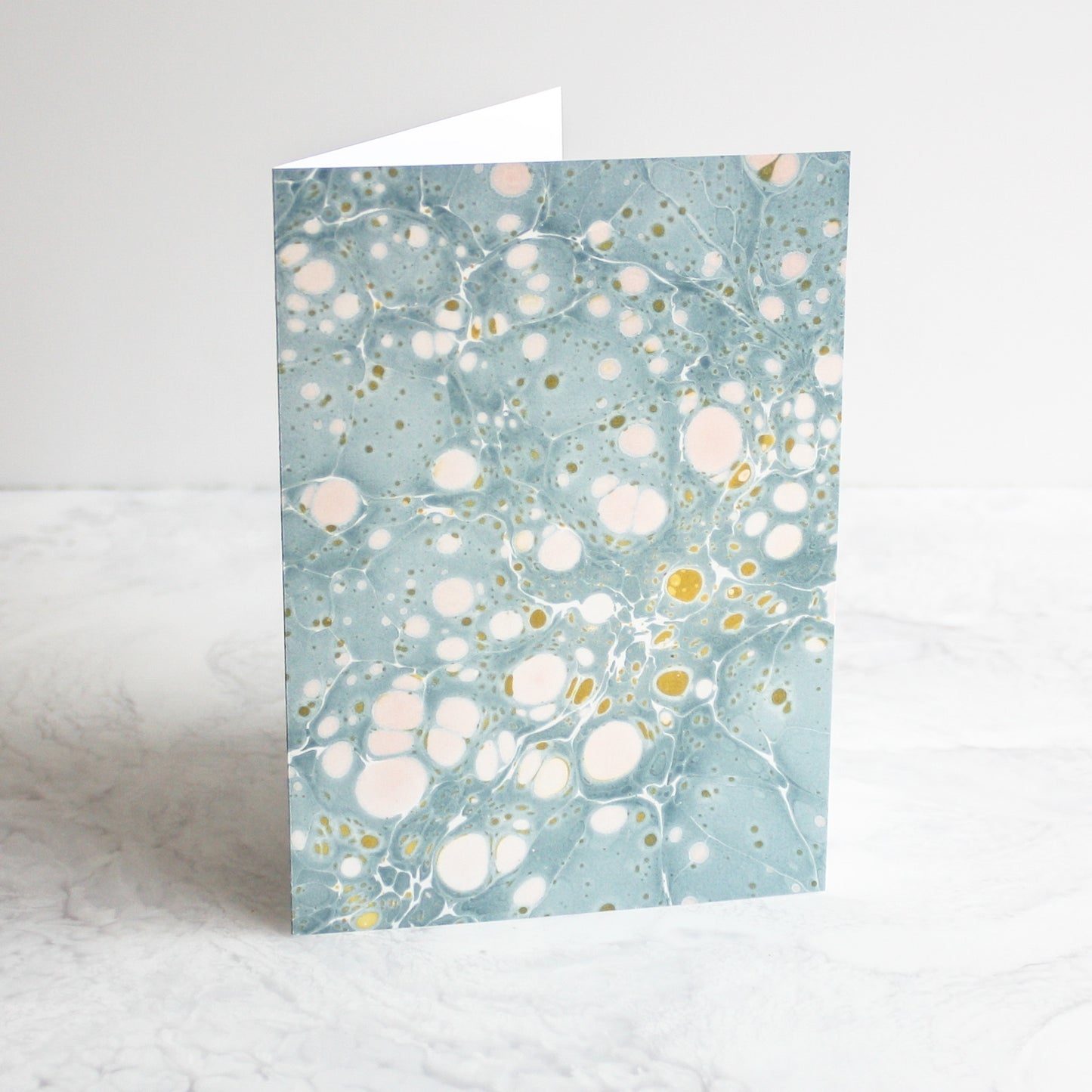Marbleized greeting cards in golden dust